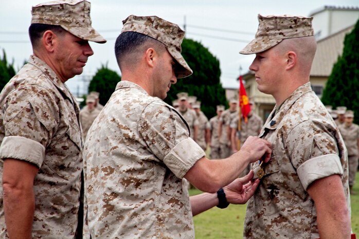 Lt. Col. Michael C. Taylor, Marine Wing Support Squadron 171 commanding officer, pins Sgt. Travis Goodwin, station runway supervisor, with the Navy and Marine Corps Medal at the parade deck in here Oct. 28. The medal is the second highest non-combat award for heroism given to Navy and Marine Corps service members.
