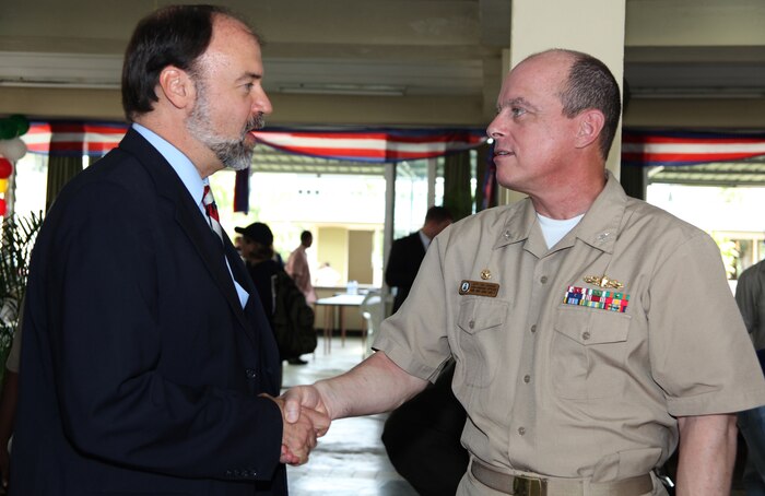 John R. Nay, U.S. Ambassador to Suriname, shakes hands with Navy Capt. Thomas J. Chassee, commanding officer of USS Iwo Jima, before the opening ceremony of CP10 at Elsje Finck Sanichar College in Paramaribo, Suriname, Oct. 29, 2010. The college is being used as a medical site for CP10 personnel to provide aid to Surinamese citizens. Marines and Sailors of CP10 are anchored off the coast of Paramaribo, Suriname to conduct humanitarian operations for 10 days. CP10 is a humanitarian civic assistance mission that provides medical, dental, veterinary, engineering support and disaster relief efforts to the Caribbean, Central and South America.