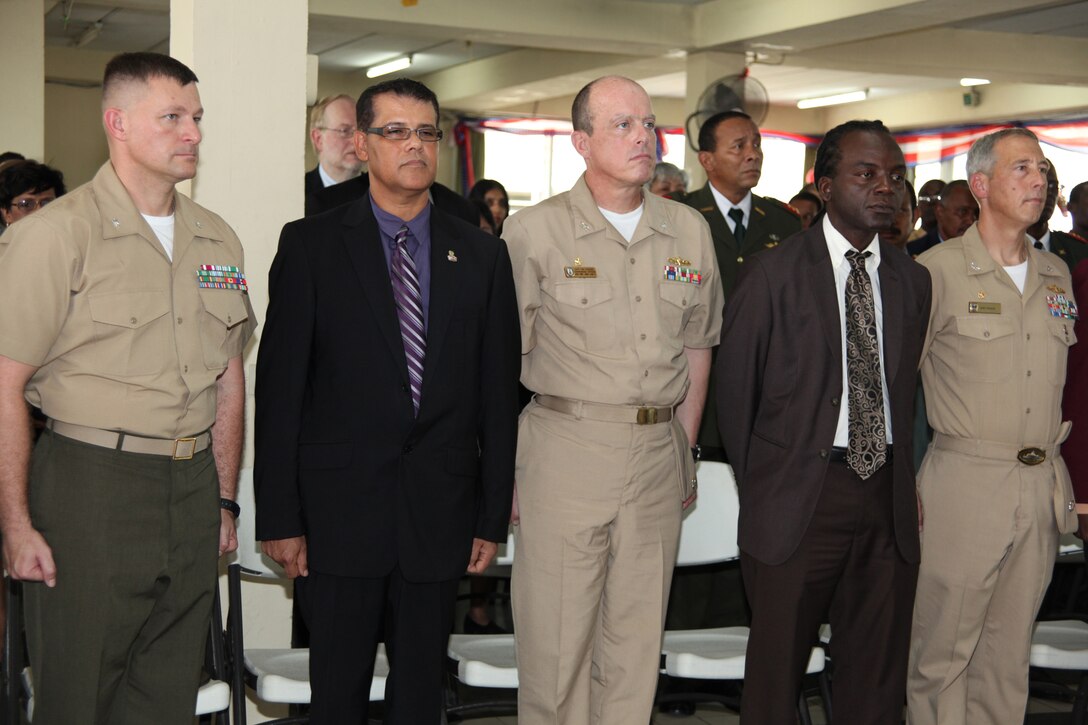 Lt. Col. Chris S. Richie, commanding officer of Special-Purpose Marine Air-Ground Task Force Continuing Promise 2010; Navy Capt. Thomas J. Chassee, commanding officer of USS Iwo Jima; and Navy Capt. Thomas M. Negus, commodore of CP10; stand at attention during the playing of the U.S. national anthem during the opening ceremony of CP10 at Elsje Finck Sanichar College in Paramaribo, Suriname, Oct. 29, 2010. The college is being used as a medical site for CP10 personnel to provide aid to Surinamese citizens. Marines and Sailors of CP10 are anchored off the coast of Paramaribo, Suriname to conduct humanitarian operations for 10 days. CP10 is a humanitarian civic assistance mission that provides medical, dental, veterinary, engineering support and disaster relief efforts to the Caribbean, Central and South America.