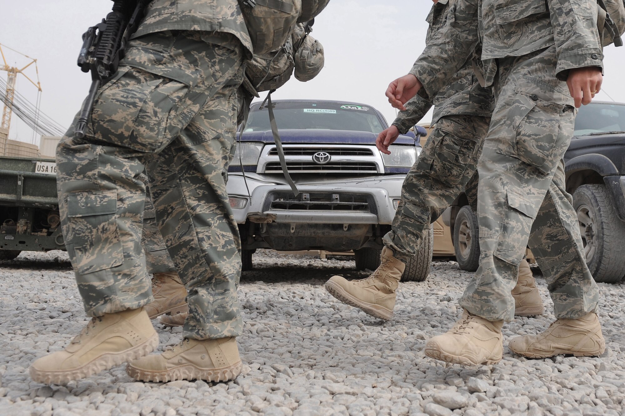 Airmen walk past a row of vehicles on their way to work Oct. 28, 2010, at Kandahar Airfield, Afghanistan.  Airmen of the 451st Air Expeditionary Wing are encouraged to walk, use the local shuttle service, and ride bikes to reduce the consumption of fuel on Kandahar Airfield.  (U.S. Air Force photo by Tech. Sgt. Chad Chisholm/Released)