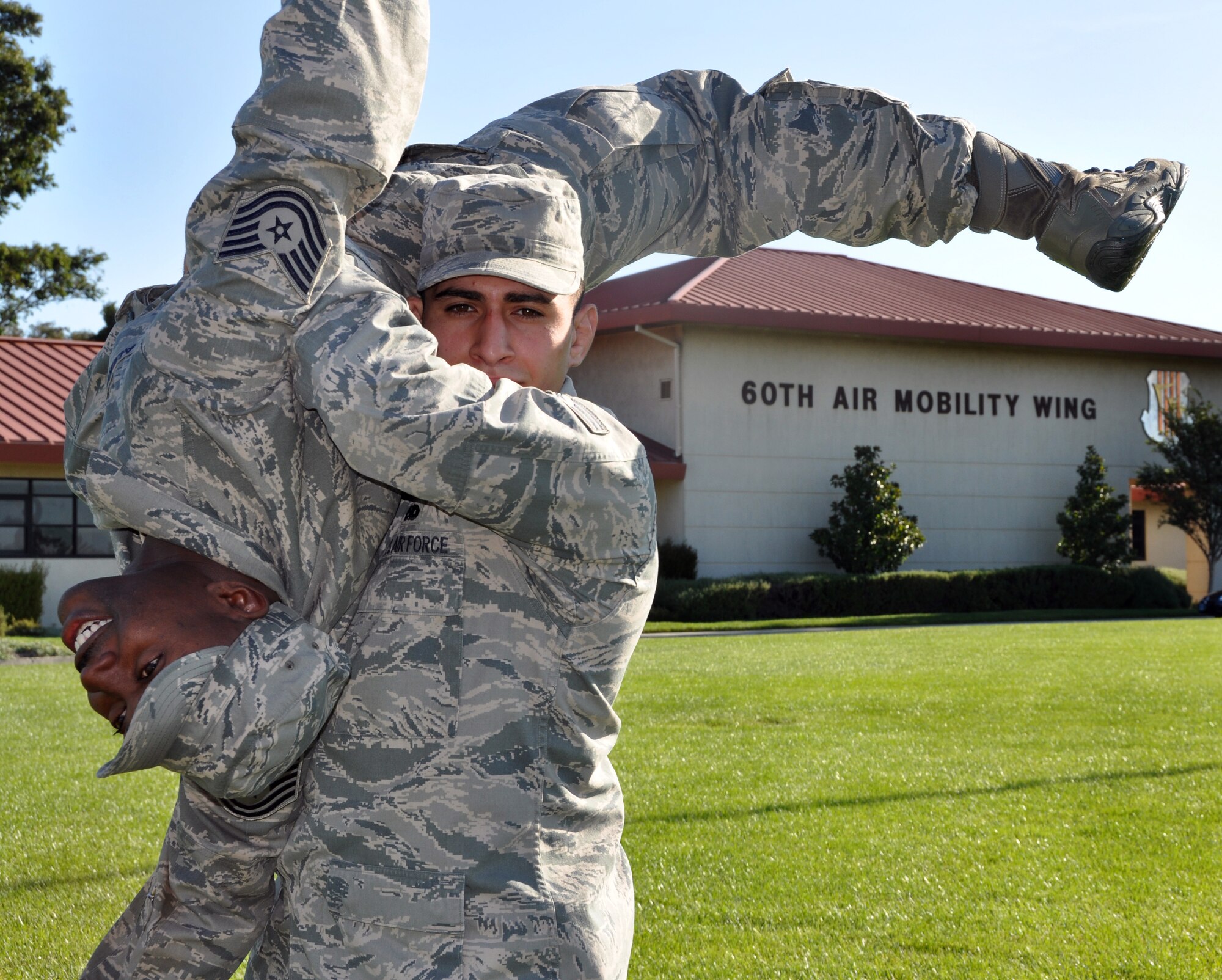 Senior Airman Nader Mahgribi, 860th Aircraft Maintenance Squadron aerospace propulsions systems journeyman, picks up his supervisor Tech. Sgt. Levar Alexander, 860th AMXS aerospace propulsion systems craftsman, to display the wrestling skills that garnered him Athlete of the Year for Air Mobility Command Oct. 27. 
