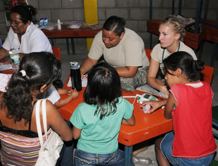 CUESTA DE LA VIRGEN, Honduras --  Staff Sgt. Jet Martinez, center, and 1st Lt. Carly Fraser, both with the Medical Element at Soto Cano Air Base, talk with a family here about their current medical needs during a Medical Readiness Exercise Training mission Oct. 28. MEDEL visited the village for two days to provide medical care to village, including immunizations and dental care. (U.S. Air Force photo/Tech. Sgt. Benjamin Rojek)