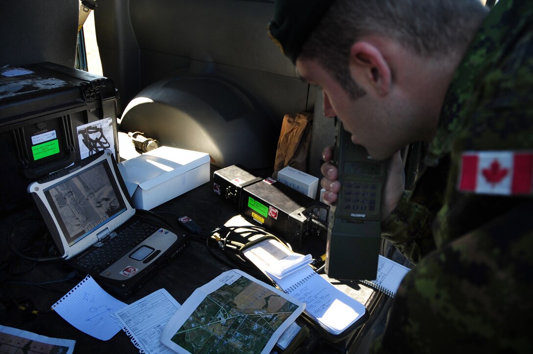 ELLSWORTH AIR FORCE BASE, S.D. -- Lt. Alex Prymack, 1st Regiment Royal Canadian Horse Artillery, radios coordinates to a B-1B Lancer while examining live Sniper pod footage during a joint-nation training mission with Canadian joint terminal attack controllers in Alzada, MT, Oct. 28.  The Sniper pod gives the B-1 the ability to positively identify targets, without additional aids such as other aircraft or ground personnel. (U.S. Air Force photo/Airman 1st Class Anthony Sanchelli)
