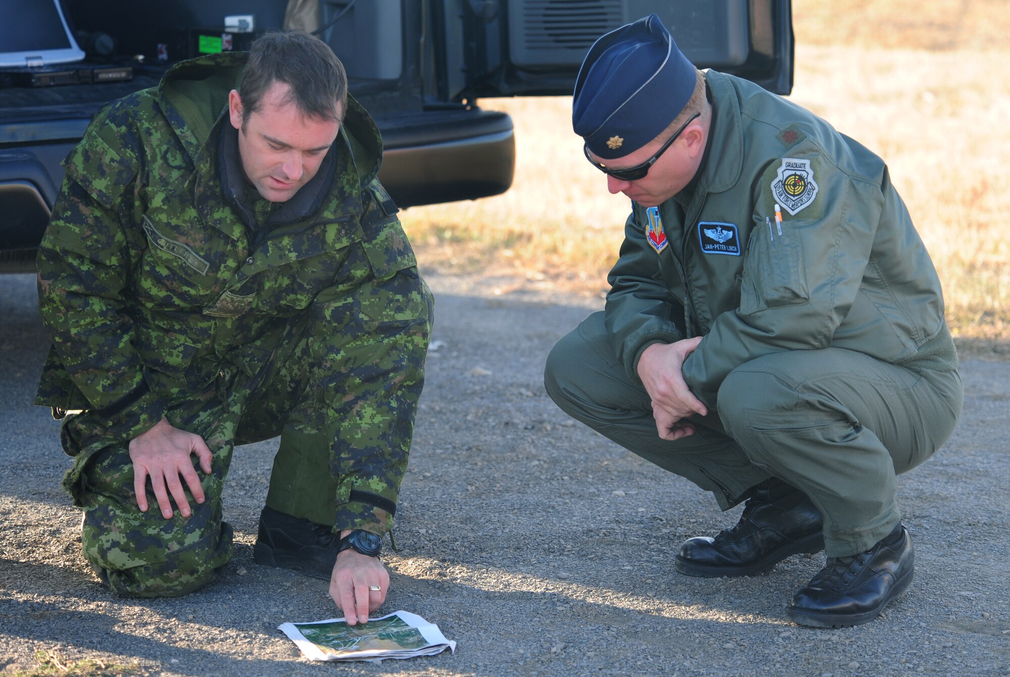 ELLSWORTH AIR FORCE BASE, S.D. -- (Right to left) Maj. Jan-Peter Linch, 28th Bomb Wing wing weapons officer, and Sgt. Aaron Cutler, 1st Regiment Royal Canadian Horse Artillery, look over a map during a joint-nation training mission between B-1 aircrew and Canadian joint terminal attack controllers in Alzada, MT, Oct. 28.  The training provided a different perspective for B-1 pilots and JTAC personnel by combining joint-nation training with air to ground support. (U.S. Air Force photo/Airman 1st Class Anthony Sanchelli)

