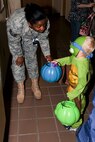 MINOT AIR FORCE BASE, N.D. -- Tech. Sgt. Geisha Patton, 5th Medical Support Squadron radiology technician, hands candy to Decklin, 3-year-old boy of Staff Sgt. Andrea Regina 791st Missile Security Forces Squadron security manager, during a ‘trick or treating’ event at the 5th Medical Group here Oct. 29. Events like these keep Airmen and family morale and spirits high as cold and snow become a mainstay for Team Minot. (U.S. Air Force photo by Senior Airman Benjamin Stratton)