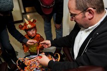 MINOT AIR FORCE BASE, N.D. -- Sterling, 18 months, and her parents, Senior Airman Clair Redd, 791st Missile Security Forces Squadron security forces team member, and Senior Airman Blake Redd, 91st Security Forces Squadron security forces team member, receives candy from Dan Barnes, 5th Force Support Squadron unit program manager, during a ‘trick or treating’ event at the PRIDE building here Oct. 29. Events like these keep Airmen and family morale and spirits high as cold and snow become a mainstay for Team Minot. (U.S. Air Force photo by Senior Airman Benjamin Stratton)