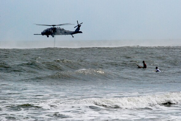 COCOA BEACH, Fla. -  A surfer takes a break from waveriding to watch an Air Force HH-60G Pave Hawk helicopter during a 920th Rescue Wing's Air Force Week performance Oct. 29, 2010. The endless summer sanctuary that is Cocoa Beach was the staging spot for Air Force Week 2010, a culmination of recruiting magnificence that happens only twice a year at select locations. The first was in New York City earlier this year. More important than attracting new blood, top Air Force leadership were here honoring the accomplishments and sacrifices of all American. With well over 35,000 Airmen currently deployed across the globe in support of contingency operations, the theme of this Air Force Week is Honoring Hometown Heroes. (U.S. Air Force Photo/Capt. Cathleen Snow)

