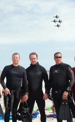 COCOA BEACH, Fla. -  After performing an astronaut rescue demonstration for Air Force Week, Air Force pararescuemen, or PJs, from Patrick Air Force Base's 920th Rescue Wing, pose for a photo as the U.S. Air Force Thunderbird demonstration team flys by Oct. 29, 2010. The endless summer sanctuary that is Cocoa Beach was the staging spot for Air Force Week 2010, a culmination of recruiting magnificence that happens only twice a year at select locations. The first was in New York City earlier this year. More important than attracting new blood, top Air Force leadership were here honoring the accomplishments and sacrifices of all American. With well over 35,000 Airmen currently deployed across the globe in support of contingency operations, the theme of this Air Force Week is Honoring Hometown Heroes. Air Force Week ran from Oct. 26 through 31. (U.S. Air Force Photo/Capt. Cathleen Snow)