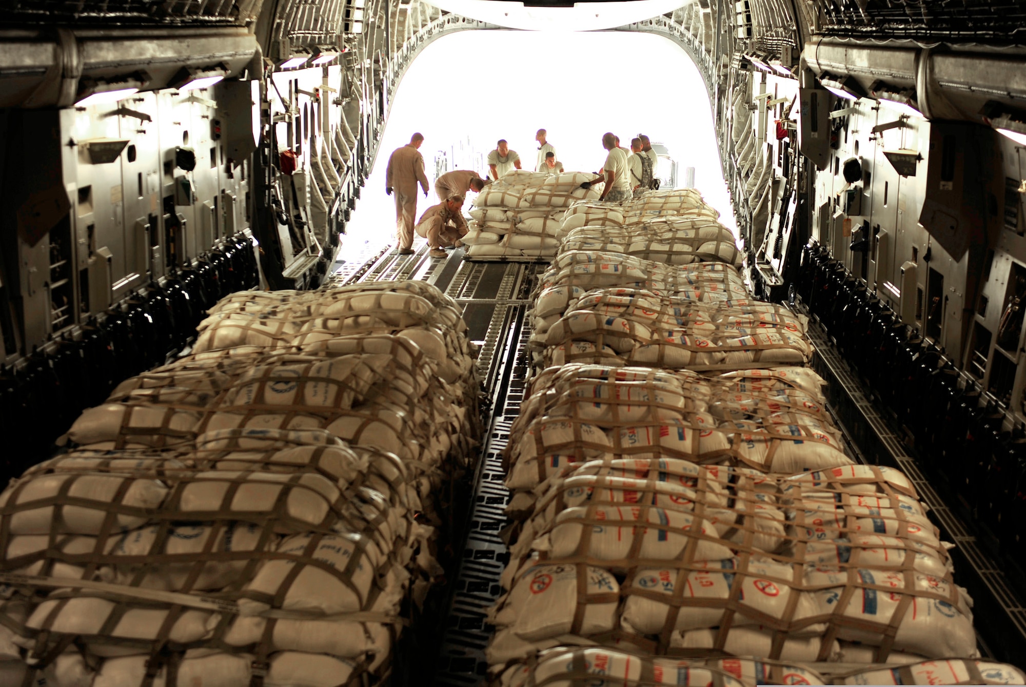 Airmen with the Contingency Response Element and the 816th Expeditionary Airlift Squadron load pallets of flour into a C-17 Globemaster III aircraft Sept. 24, 2010 at Pakistan Air Force Base Chaklala, Pakistan. The Airmen flew supply missions to northern Pakistan and displaced persons to Chaklala Air Force Base. The CRE Airmen are deployed from the 621st Contingency Response Wing at Joint Base McGuire-Dix-Lakehurst, N.J. (U.S. Air Force Photo/Staff Sgt. Andy M. Kin)