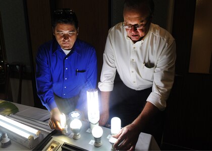 A sample display of various energy saving LED lights is adjusted by Doug Bennefield, Energy Design Group, and Larry Jones, LED Illumination Direct, during and Energy Fair at Randolph Air Force Base, Texas, Oct. 27. Numerous vendors displayed devices which provide energy savings for the Air Force. The one-day fair was held at the Kendrick Enlisted Club. (U.S. Air Force photo/David Terry)