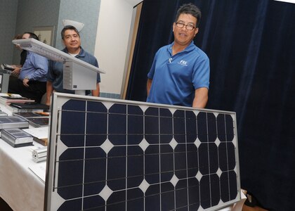 Randolph AFB, TX, 10/27/2010:  A solar panel is displayed by Ray Medina, right, account manager with Facility Solutions Group, San Antonio, during an Energy Fair at Randolph Air Force Base, Texas.  On the left is Steve Tristan with RKI Texas. The Energy Fair provided Randolph personnel the opportunity to view innovations in solar technology, energy efficient building materials, insulations and lighting. 
(U.S. Air Force photo/David Terry)