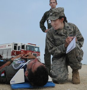 Maj Jason Kelley, 359th Aerospace Medical Squadron flight surgeon, looks on as Capt Karen Dombkoski, flight nurse, gathers information about the injured pilot before transporting during a base exercise at Randolph AFB.  
( U.S. Air Force Photo By Don Lindsey)