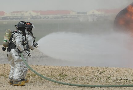 Senior Airman Kenneth Blum and Staff Sgt. Justin Hrusovsky, 902nd Civil Engineer Squadron firefighters, fight an aircraft fire during  an aircraft accident and first responder exercise at Randolph Air Force Base, Texas, Oct. 27.  (U. S. Air Force Photo/Don Lindsey)