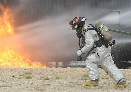 Senior Airman Kenneth Blum, assigned to Randolph Fire Department, carries a firehose in preparation to extinguish aircraft fire.  
(U.S. Air Force Photo By Don Lindsey)