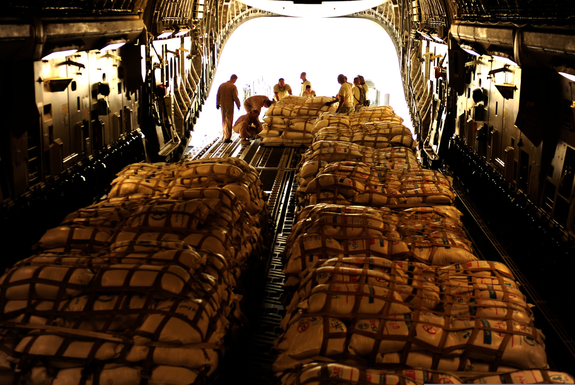 Airmen with the Contingency Response Element and the 816th Expeditionary Airlift Squadron load pallets of flour into a C-17 Globemaster III aircraft at Pakistan Air Force Base Chaklala, Pakistan, Sept. 24, 2010. The Airmen flew supply missions to northern Pakistan and displaced persons to Chaklala Air Force Base, Pakistan. The CRE Airmen are deployed from the 621st Contingency Response Wing at Joint Base McGuire-Dix-Lakehurst, N.J. (U.S. Air Force Photo/Staff Sgt. Andy M. Kin)