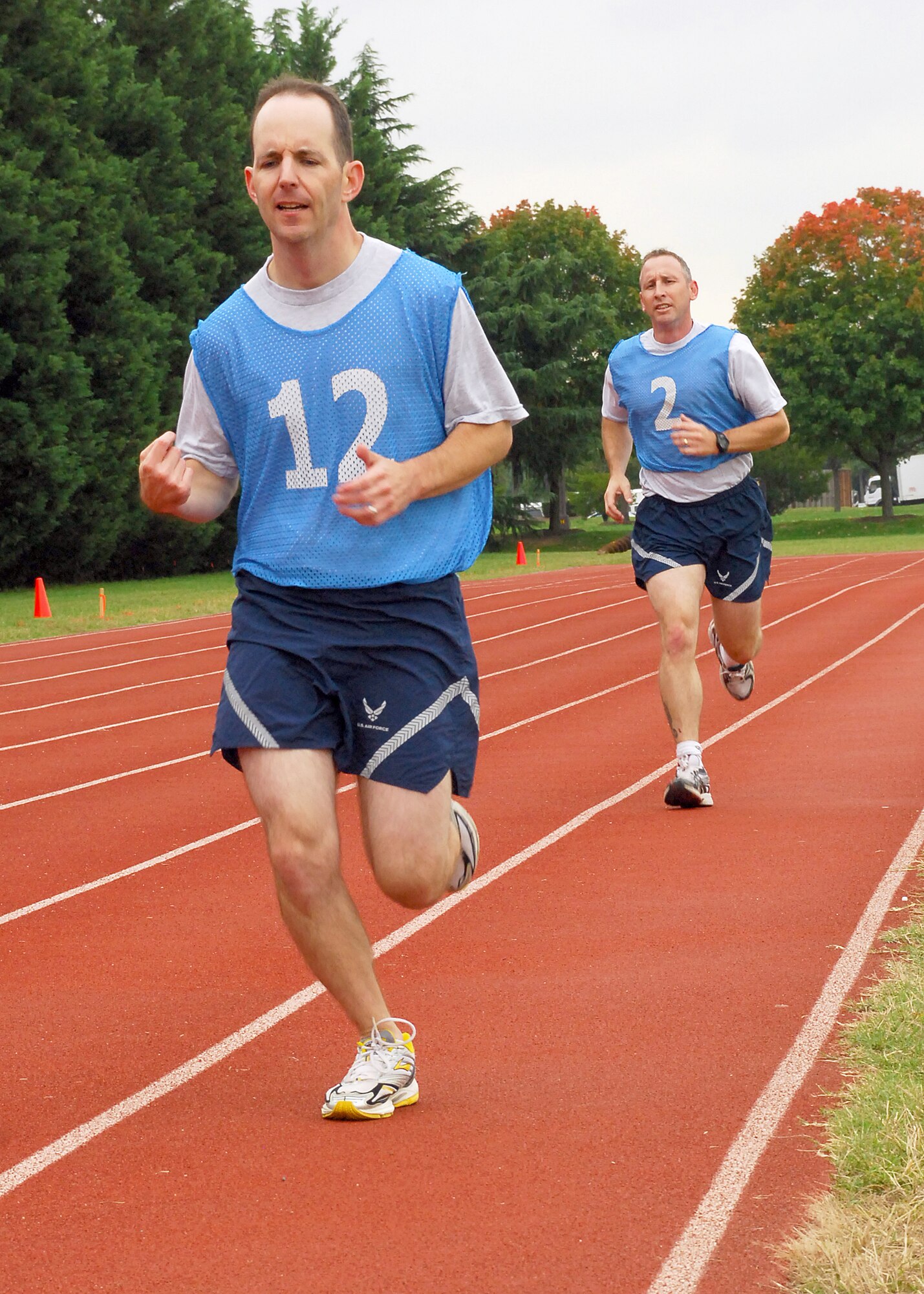 Air Force members sprint toward the finish line to complete their 1.5-mile run of the Air Force fitness test at Joint Base Anacostia-Bolling Oct 19. The Air Force uses an overall composite fitness score and minimum scores per component based on aerobic fitness, body composition and muscular fitness components to determine overall fitness. While taking the fitness test at Joint Base Anacostia-Bolling, members wear a numbered jersey to be identified. (U.S. Air Force photo/Master Sgt. Raheem Moore)