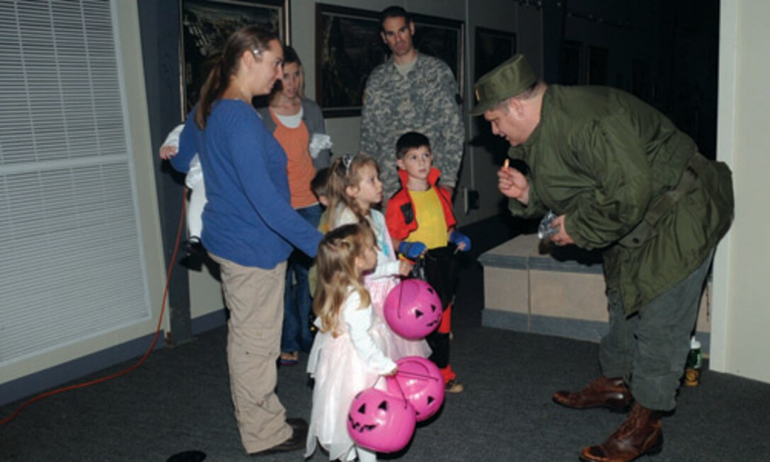 Air Force pilot Gail Halvorsen, the original “Candy Bomber,” aka Army Transportation Museum Assistant Curator James Atwater, hands out parachute men toys and candy to the young visitors. Halvorsen was dubbed the “Candy Bomber” for dropping candy attached to miniature parachutes to children during the Berlin Airlift in World War II. 
