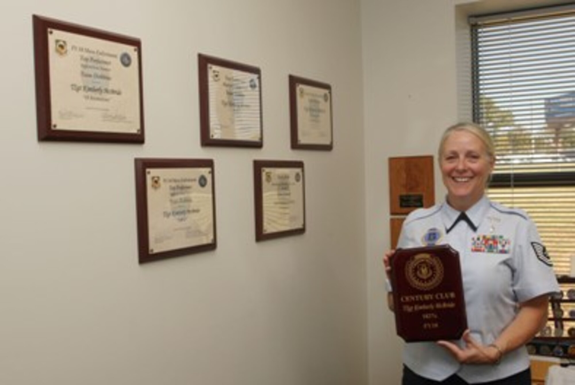Tech. Sgt. Kimberly McBride  holds the Century Club award plaque she earned in September by enlisting 182 percent of her assigned Air Force Reserve Recruiting goal. 

