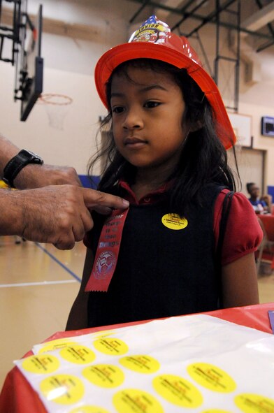 BARKSDALE AIR FORCE BASE, La. -- Rianna Davis, 5, daughter of Tech. Sgt. Regie Alejandro, 2nd Medical Support Squadron receives a red ribbon after she signs the pledge declaring that she will remain drug free during Red Ribbon Week at the youth center Oct. 28. Each child in attendance received a backpack filled with goodies. (U.S. Air Force photo/Senior Airman La'Shanette V. Garrett)