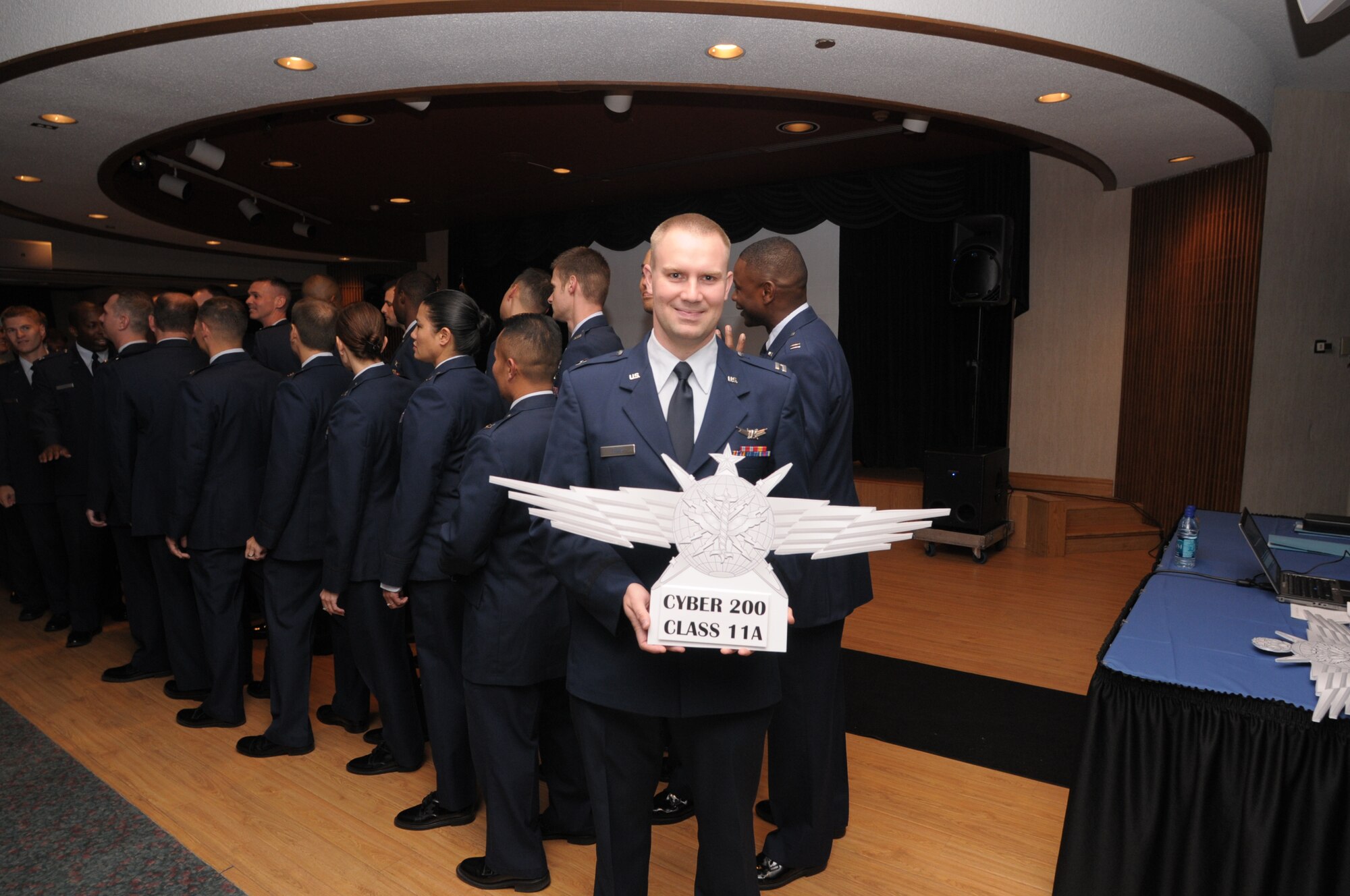 Capt Travis Tubbs, class leader for the first Air Force Institute of Technology Cyber 200 class, holds the new Air Force cyberspace operator badge during graduation ceremonies, Oct. 28, 2010, at Wright-Patterson Air Force Base, Ohio.  (U.S. Air Force photo/Al Bright)