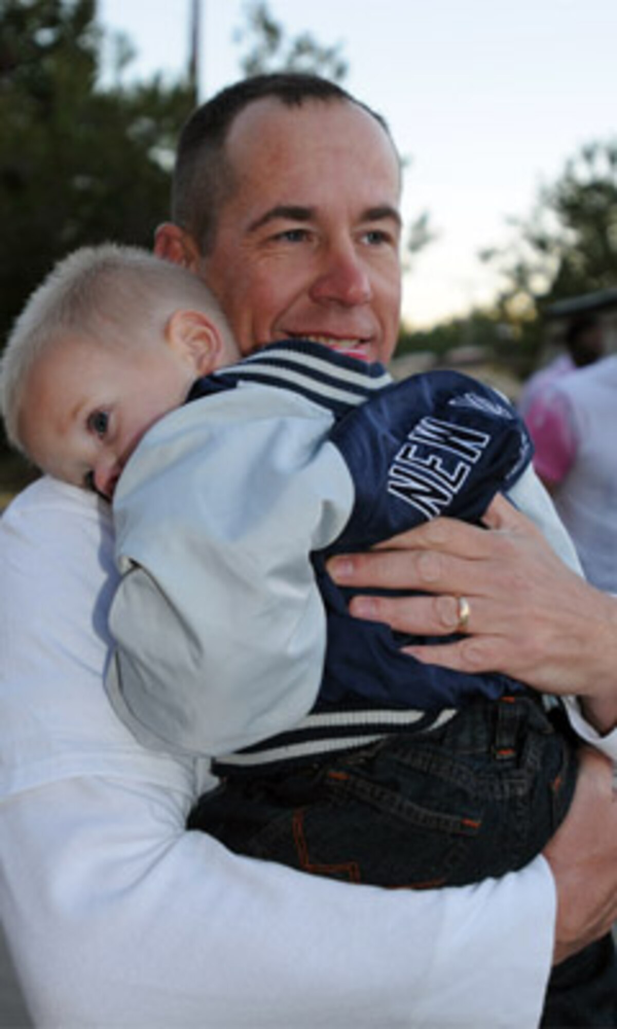 Cpl. Jonathan Lee, 73rd Transportation Company, 10th Transportation Battalion, 7th Sustainment Brigade, holds his young son as his wife talks about her experience fighting breast cancer.