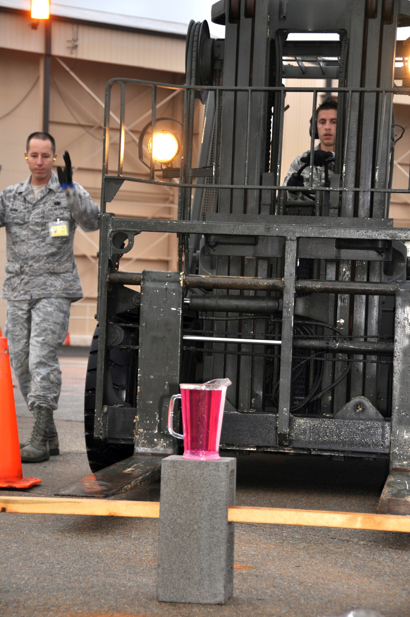 Tech. Sgt. Justin Adams (left) guides Senior Airman Sterling Broadhead through a driving course Oct. 29, 2010, during the Port Dawg Challenge at Dobbins Air Reserve Base, Ga. In the timed event, Airman Broadhead had to maneuver a forklift through cones without spilling the contents of the pitcher. Sergeant Adams and Airman Broadhead are both assigned to the 67th Aerial Port Squadron from Hill Air Force Base, Utah. (U.S. Air Force photo/Bryan Magaña)