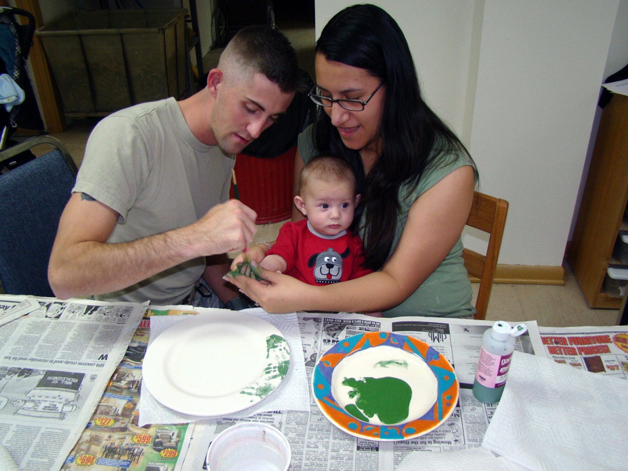 Staff Sgt. and Mrs. Jason Belcher, 90th Missile Security Forces Squadron, and their son, Domanic, make a plate in Warren’s Arts & Crafts Center during the Squadron Day on Oct. 8. (U.S. Air Force photo by Maj. Joel Briske)