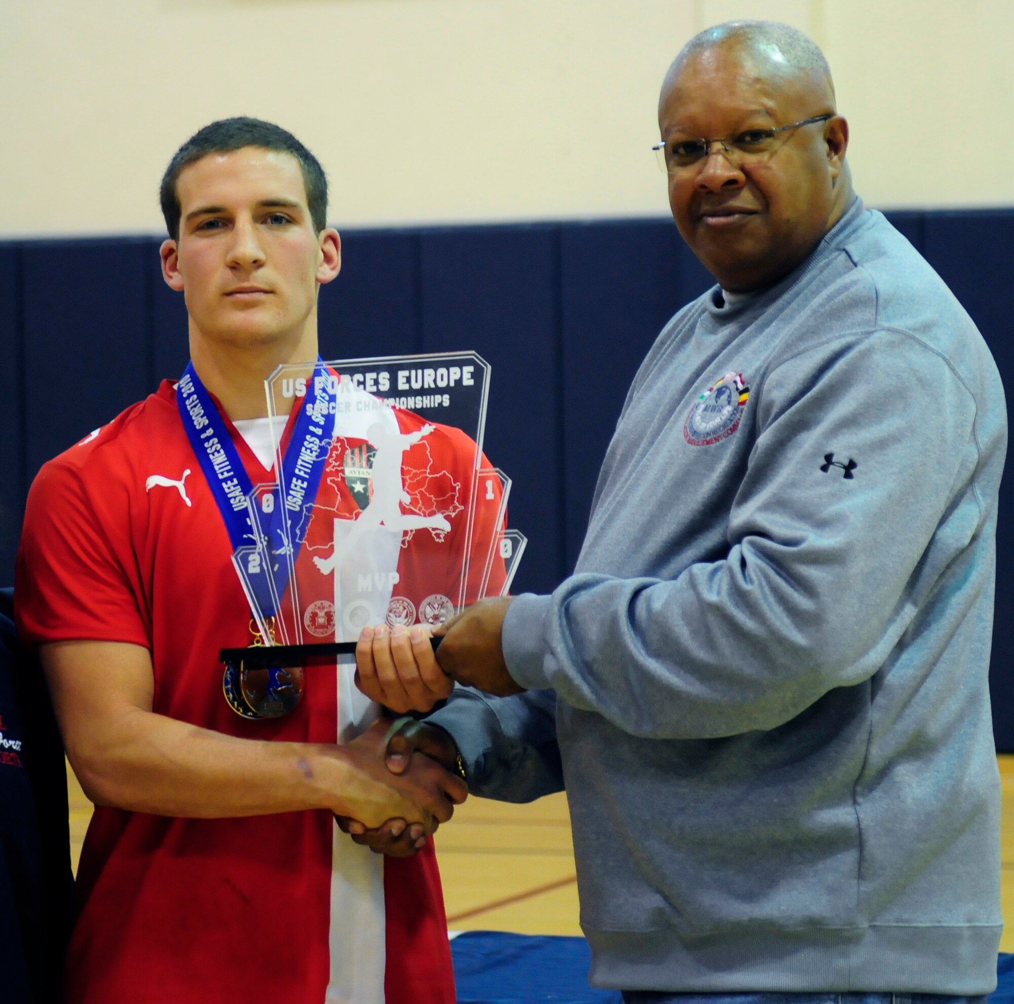 Luke Mornini, Aviano Dragons, receives the Most Valuable Player award during the U.S. Armed Forces Europe Soccer Championship Award Ceremony Oct. 24 at the Dragon Fitness Center. There were 24 games during the four-day championship, culminating in a final game between the Lakenheath and Aviano teams, Aviano emerging the victor, 2-1. (U.S. Air Force photo by Airman 1st Class Katherine Windish)