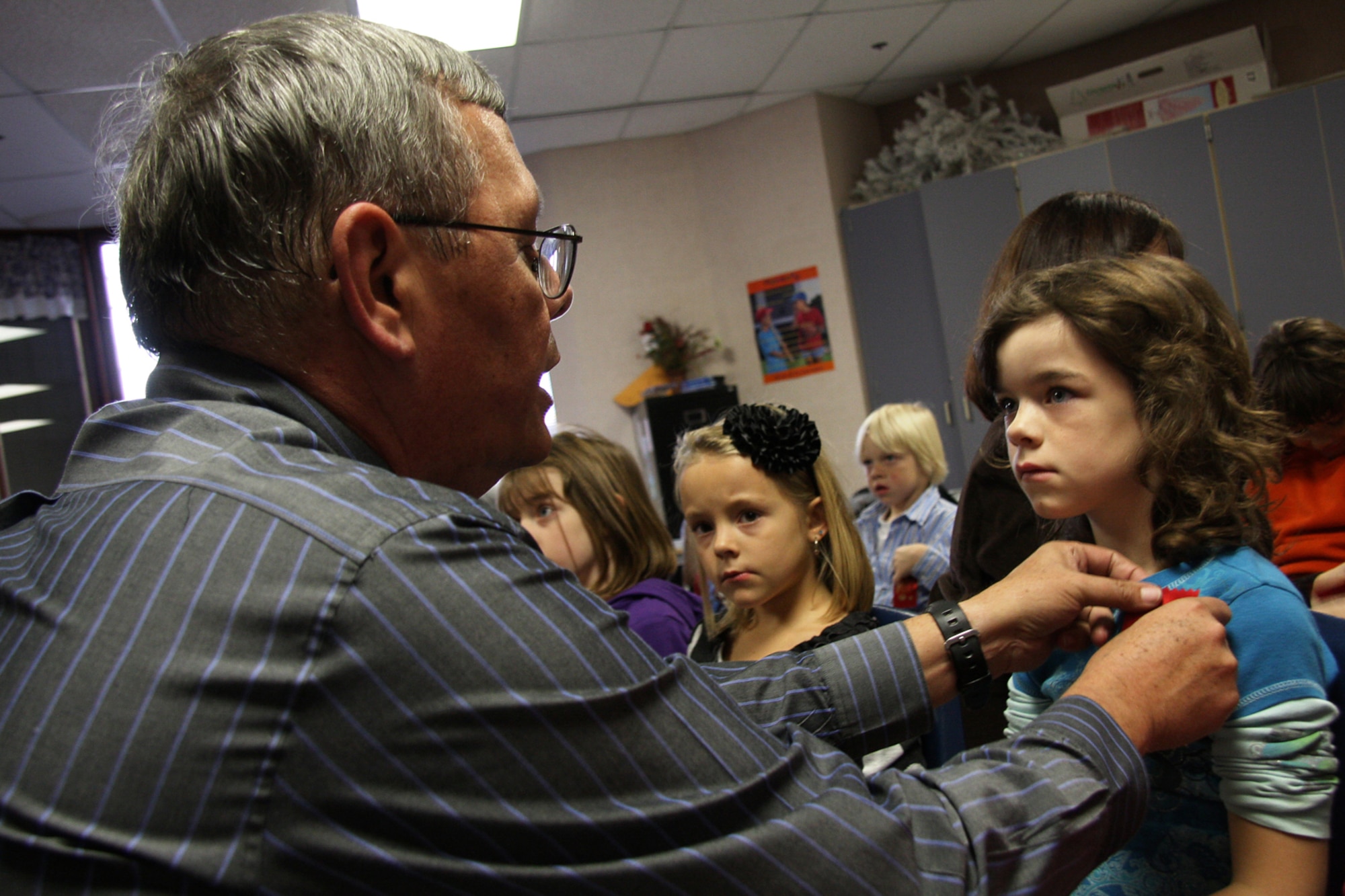 GRISSOM AIR RESERVE BASE, Ind. -- Gary Flook pins a red ribbon on a first grader at Pipe Creek Elementary School Oct. 28 during a special presentation in support of Red Ribbon Week. Mr. Flook, a drug demand reduction specialist at Grissom, and other base personnel held several classes to teach kids about the dangers of drug and alcohol use. Red Ribbon Week is the nation's oldest and largest drug prevention program in the nation reaching millions of Americans during the last week of October every year. (U.S. Air Force photo/Tech. Sgt. Mark R. W. Orders-Woempner)