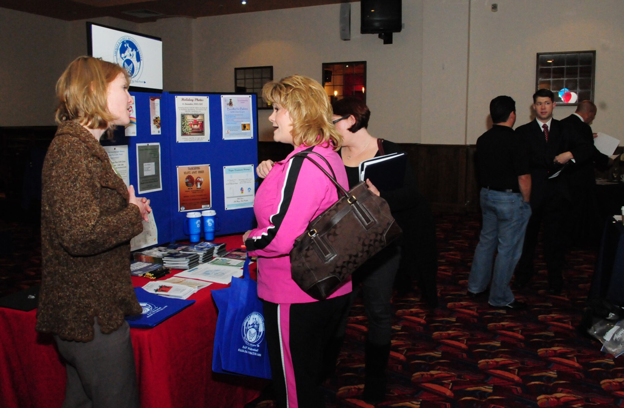 RAF MILDENHALL, England -- Jennifer Johnson (left), Airman and Family Readiness Center, offers career focus information and explains the resources offered by the A&FRC to Kathy Brunson, attendee at the Employment Exposition at the Galaxy Club Oct. 28. Various U.S. employers, government agencies and base agencies were on hand to talk about employment opportunities and offer advice to members preparing to retire or separate, and those who have already retired. (U.S. Air Force photo/Karen Abeyasekere)