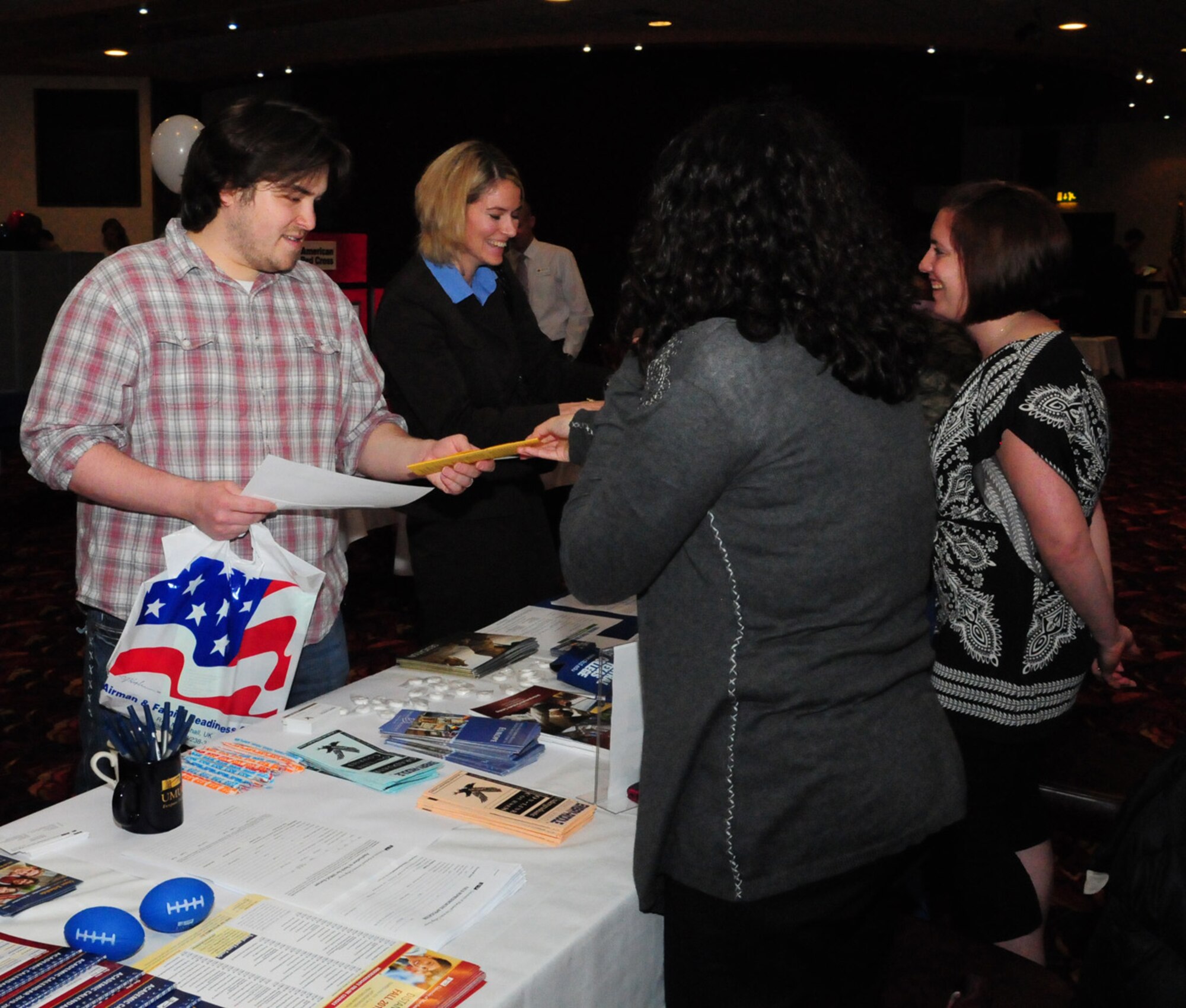 RAF MILDENHALL, England -- Codie Seier, (right), Embry Riddle assistant director of academic support, and Erika Yourdan, (second right), University of Maryland University College field representative, talk to people interested in faculty positions at the Employment Exposition Oct. 28 at the Galaxy Club. The universities were just part of the potential employers and advisors at the event held for retirees and those preparing to separate or retire from the Air Force. (U.S. Air Force photo/Karen Abeyasekere)