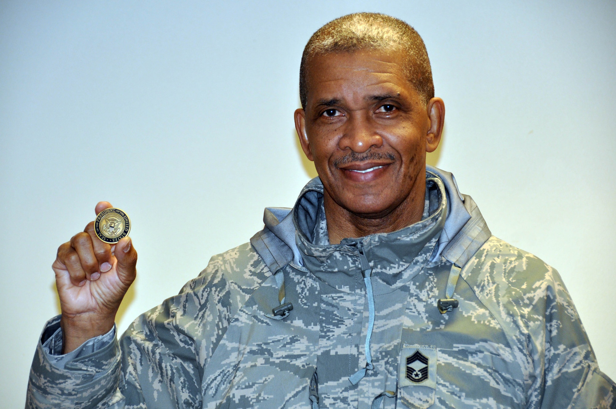 Chief Master Sgt. Reuben Evans displays the coin he received from President Barack Obama during his visit to the 934th Airlift Wing Oct. 23.  The President presented the coin to chief Evans in recognition of his 36 years of service. The Chief retired from the Air Force Reserve and civil service Oct. 28. (Air Force Photo/Paul Zadach)