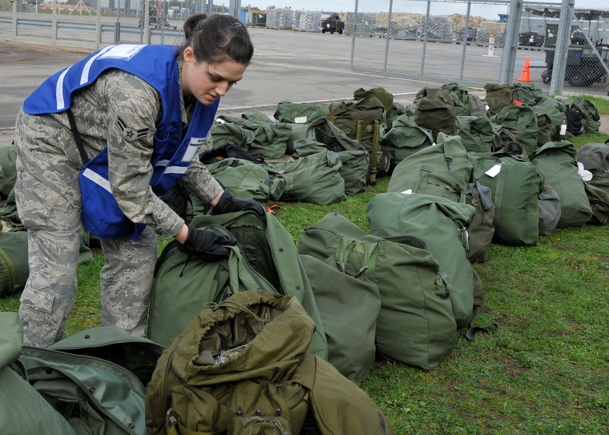 ROYAL AIR FORCE LAKENHEATH, England – Airman 1st Class Kristen Williams, 48th Logistics Readiness Squadron supply customer service apprentice, inspects mobility bags for necessary deployment items and unauthorized items outside the 48th Logistics Readiness Squadron Liberty Wing Deployment Center during a deployment process on Oct. 27. The Airmen that are deploying will be going to Saxon Air Base, Anglia, to support Operation Eagle Anglia through the stabilization of the region, evacuation of non-essential personnel if necessary and the providing of support for humanitarian efforts as required. (U.S. Air Force photo/Airman 1st Class Tiffany M. Deuel)