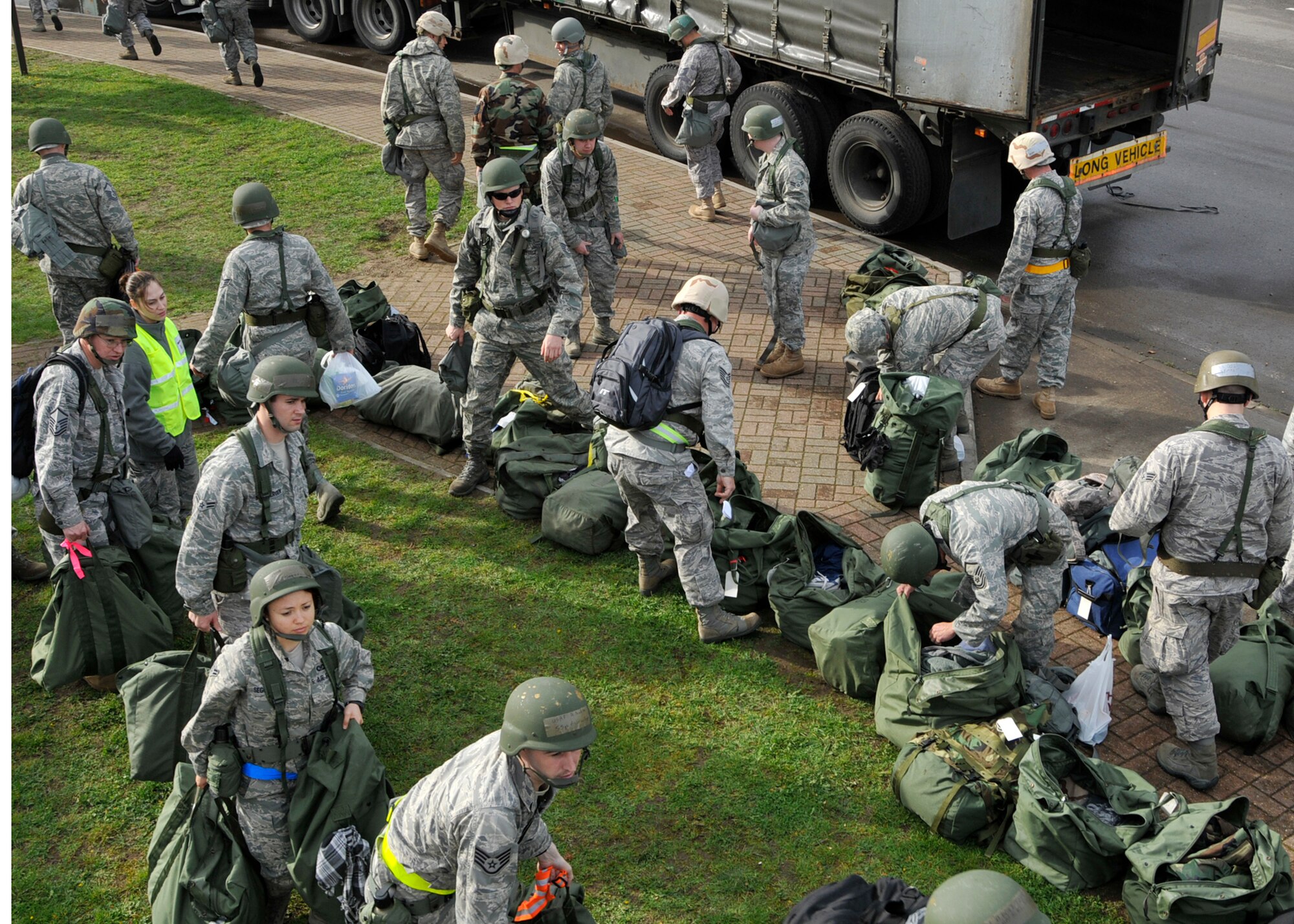 ROYAL AIR FORCE LAKENHEATH, England – Members of the 48th Fighter Wing Airmen carry mobility bags to be inspected prior to entering the 48th Logistics Readiness Squadron Liberty Wing Deployment Center for their mock pre-deployment briefings and processing Oct. 27. The bags are inspected to ensure they contain all the necessary equipment for deployment and contain no illegal or unauthorized items. These Airmen were participants in a mock deployment for Phase I of the operational readiness inspection. (U.S. Air Force photo/Airman 1st Class Tiffany M. Deuel)