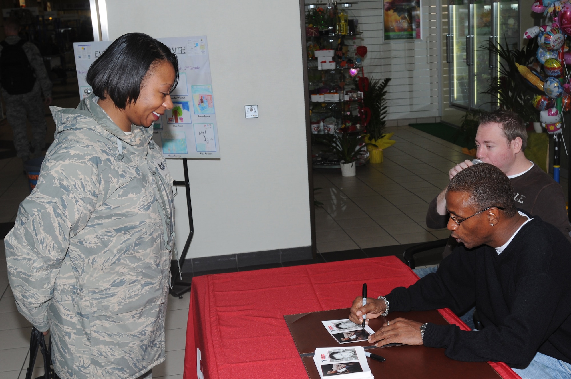 Actor and comedian Tommy Davidson autographs his photo for Tech. Sgt. Sonya Braxton, 31st Force Support Squadron NCO in charge of readiness and plans, Oct. 26 at the Aviano Base Exchange. Mr. Davidson and fellow comedian Rob Maher visited Aviano Air Base, Italy, as part of an Armed Forces Entertainment tour in support of military members stationed in Europe. (U.S. Air Force photo/Airman 1st Class LaVel Sterling)
