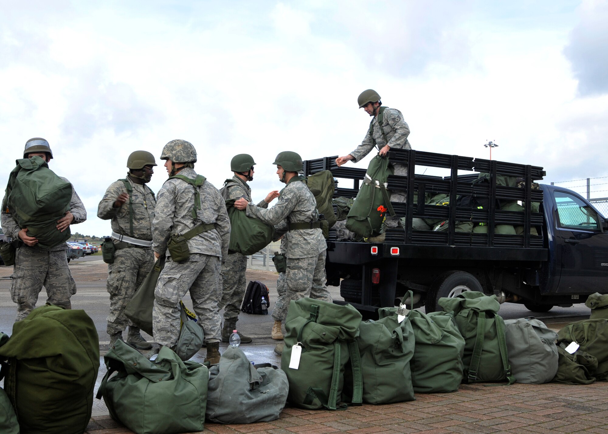 ROYAL AIR FORCE LAKENHEATH, England – Members of the 48th Fighter Wing Airmen unload mobility bags from a truck prior to entering the 48th Logistics Readiness Squadron Liberty Wing Deployment Center for their mock pre-deployment briefings and processing Oct. 27. These Airmen participated in a mock deployment during Phase I of the operational readiness inspection. (U.S. Air Force photo/Airman 1st Class Tiffany M. Deuel)