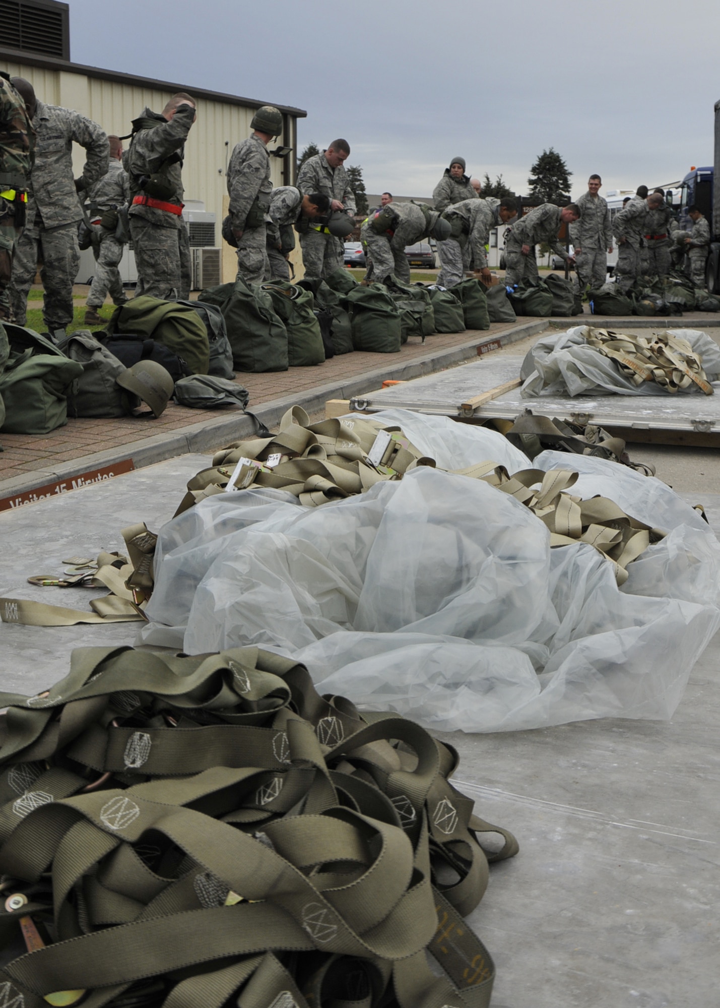 ROYAL AIR FORCE LAKENHEATH, England – 48th Fighter Wing Airmen don deployment gear from their mobility bags prior to entering the 48th Logistics Readiness Squadron Liberty Wing Deployment Center for a mock deployment exercise Oct. 26. This exercise was part of the operational readiness inspection that the wing had been preparing for. (U.S. Air Force photo/Airman 1st Class Tiffany M. Deuel)