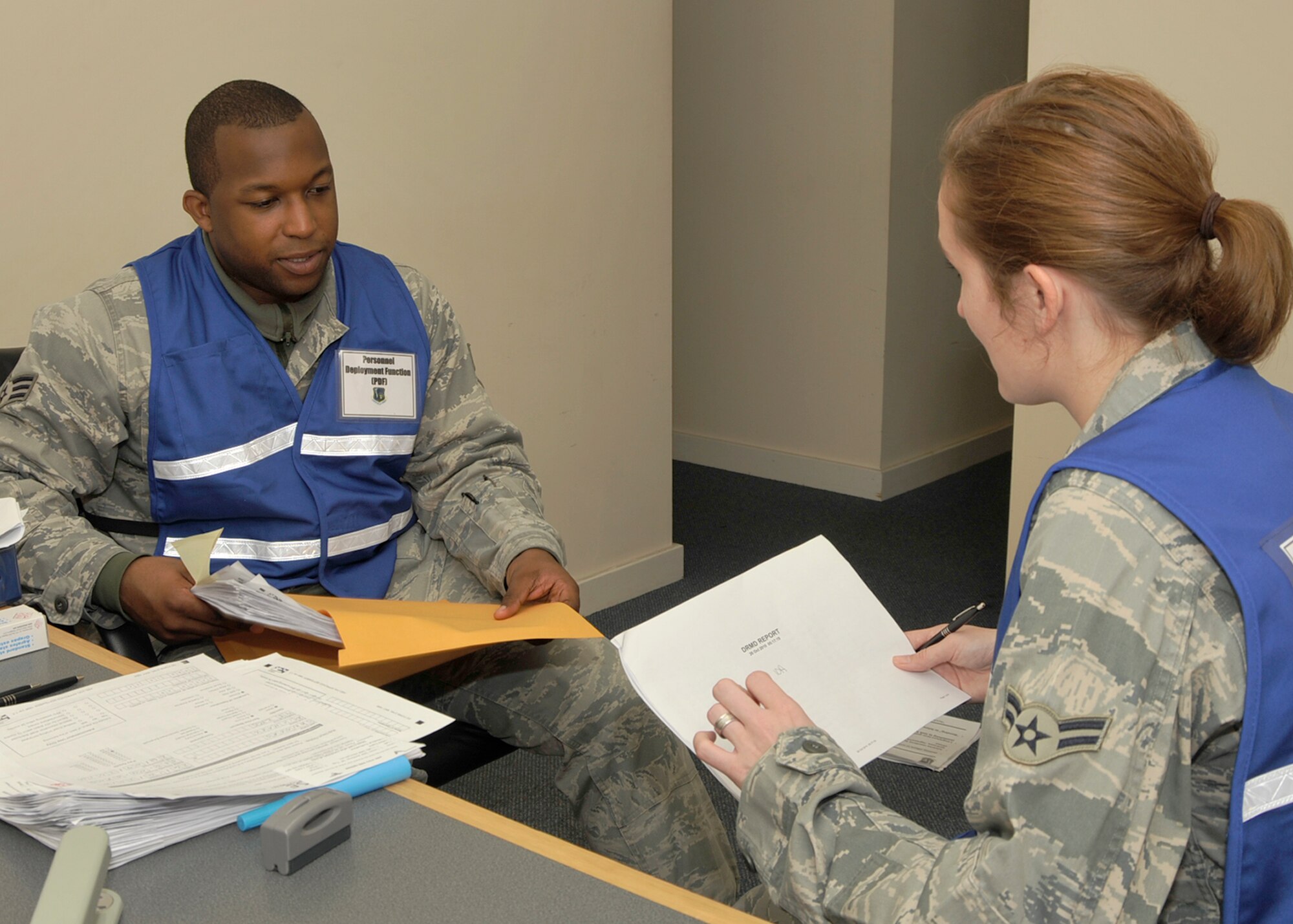 ROYAL AIR FORCE LAKENHEATH, England - Senior Airman Carlton Cooper, (left), 48th Aerospace Medical Squadron Public Health journeyman, discusses a medical form with Airman 1st Class Carol Burson, 48th AMDS Public Health technician, during a mock deployment exercise at the 48th Logistics Readiness Squadron Liberty Wing Deployment Center on Oct. 26. This exercise was one of many that the base underwent during the operational readiness inspection. (U.S. Air Force photo/Airman 1st Class Tiffany M. Deuel)
                   
