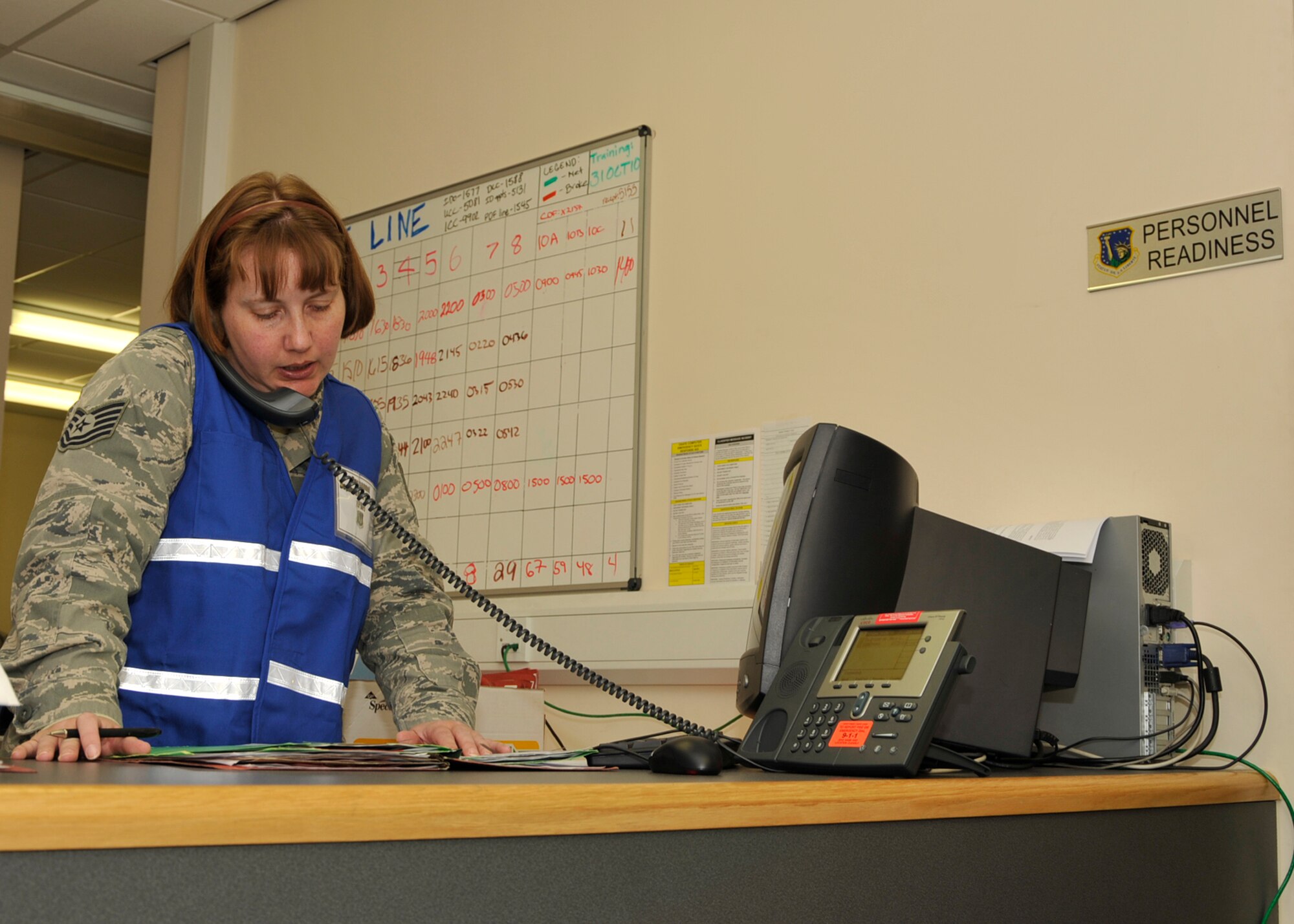 ROYAL AIR FORCE LAKENHEATH, England – Tech. Sgt. Deanna Estok, 48th Force Support Squadron NCO in charge of customer support, places a call during a mock deployment processing line at the 48th Logistics Readiness Squadron Liberty Wing Deployment Center on Oct. 26. This simulated deployment, which had been in effect for more than 24 hours, was part of the operational readiness inspection. (U.S. Air Force photo/Airman 1st Class Tiffany M. Deuel)