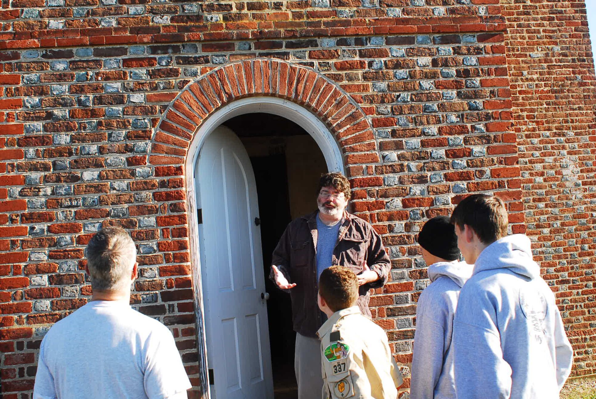 Mr. McDaid fields questions outside the Matthew Jones House from members of Boy Scout Troop 43. Matthew Jones was an early settler of Mulberry Island who owned the tract in the mid-17th century and operated a mill at the head of the Poquoson River in York County. His grandson, Matthew Jones II of Isle of Wight County, inherited the land and built the house about 1727.
