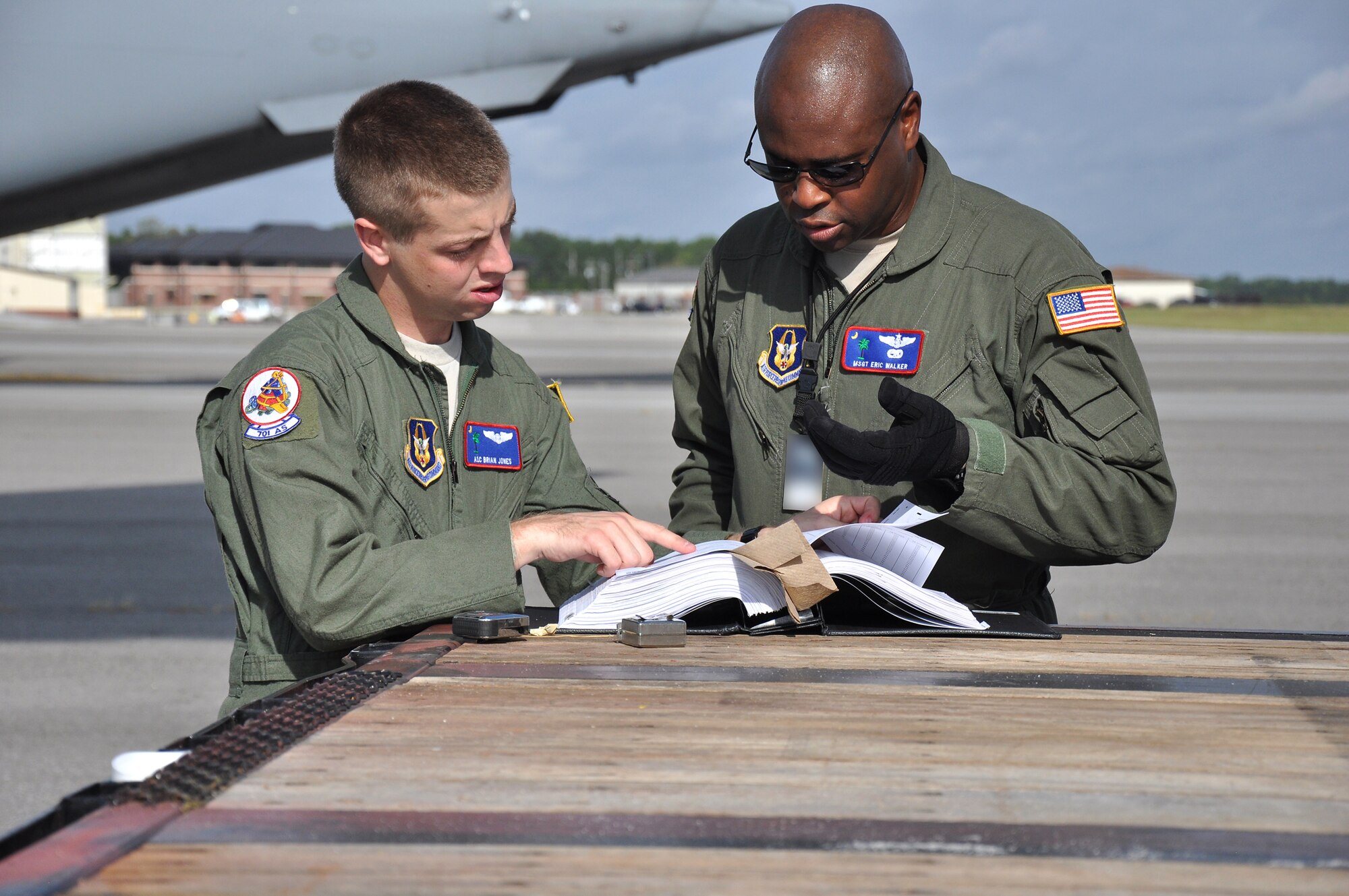 Master Sgt. Eric Walker loadmaster with the 315th Airlift Control Flight and Airman 1st Class Brian Jones, loadmaster with the 701st Squadron, review details for proper ground clearance before loading a Department of Homeland Security tractor trailer into a C-17 Globemaster III during airlift load certification training Oct. 28 at Joint Base Charleston, S.C. (U.S. Air Force Photo/ Airman 1st Class Robert Pilch)