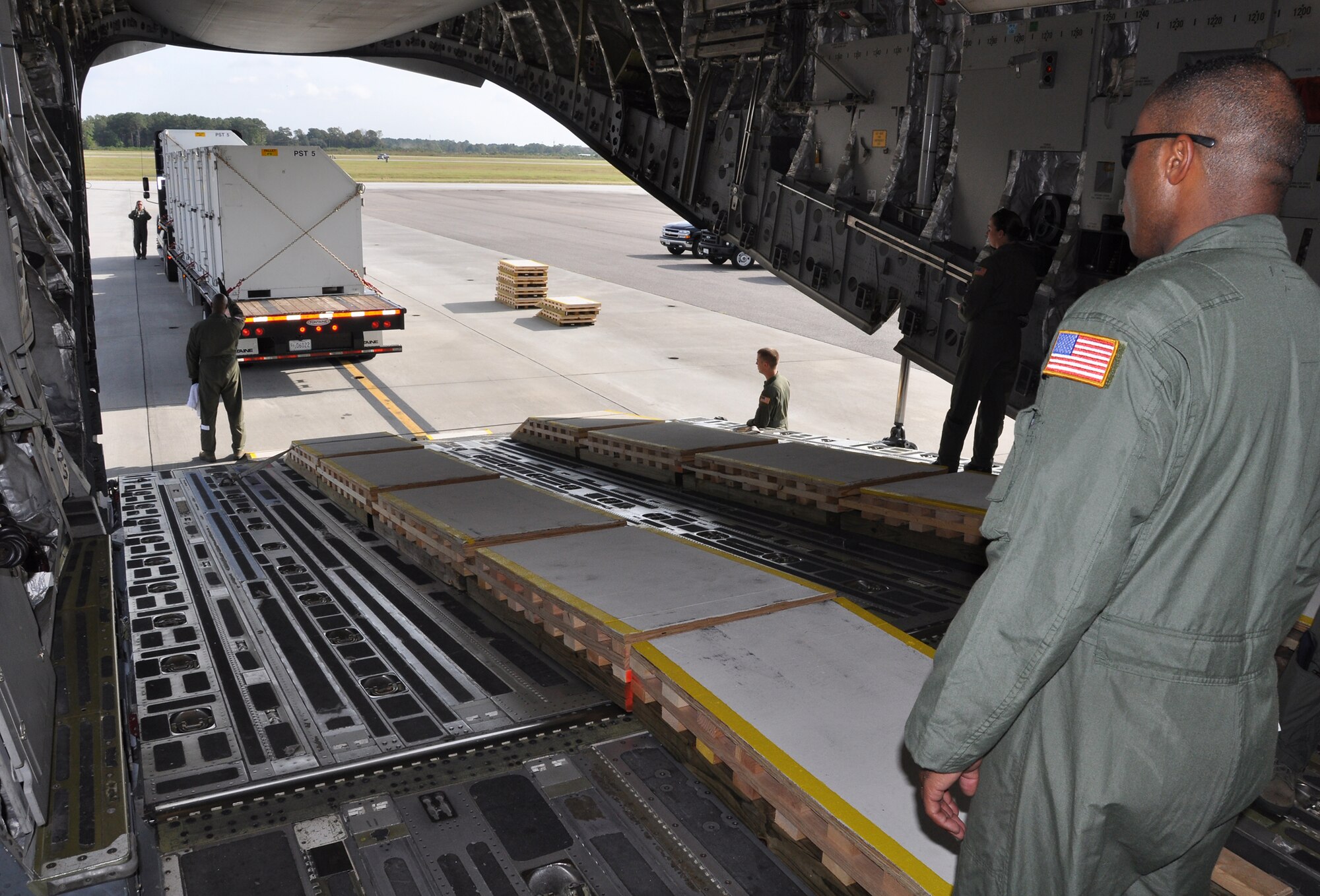 Tech. Sgt. Brian Lacy, a loadmaster with the 315th Airlift Control Flight, helps guide a Department of Homeland Security tractor trailer into a C-17 Globemaster III during airlift load certification training Oct. 28 at Joint Base Charleston, S.C.  (U.S. Air Force Photo/Michael Dukes)