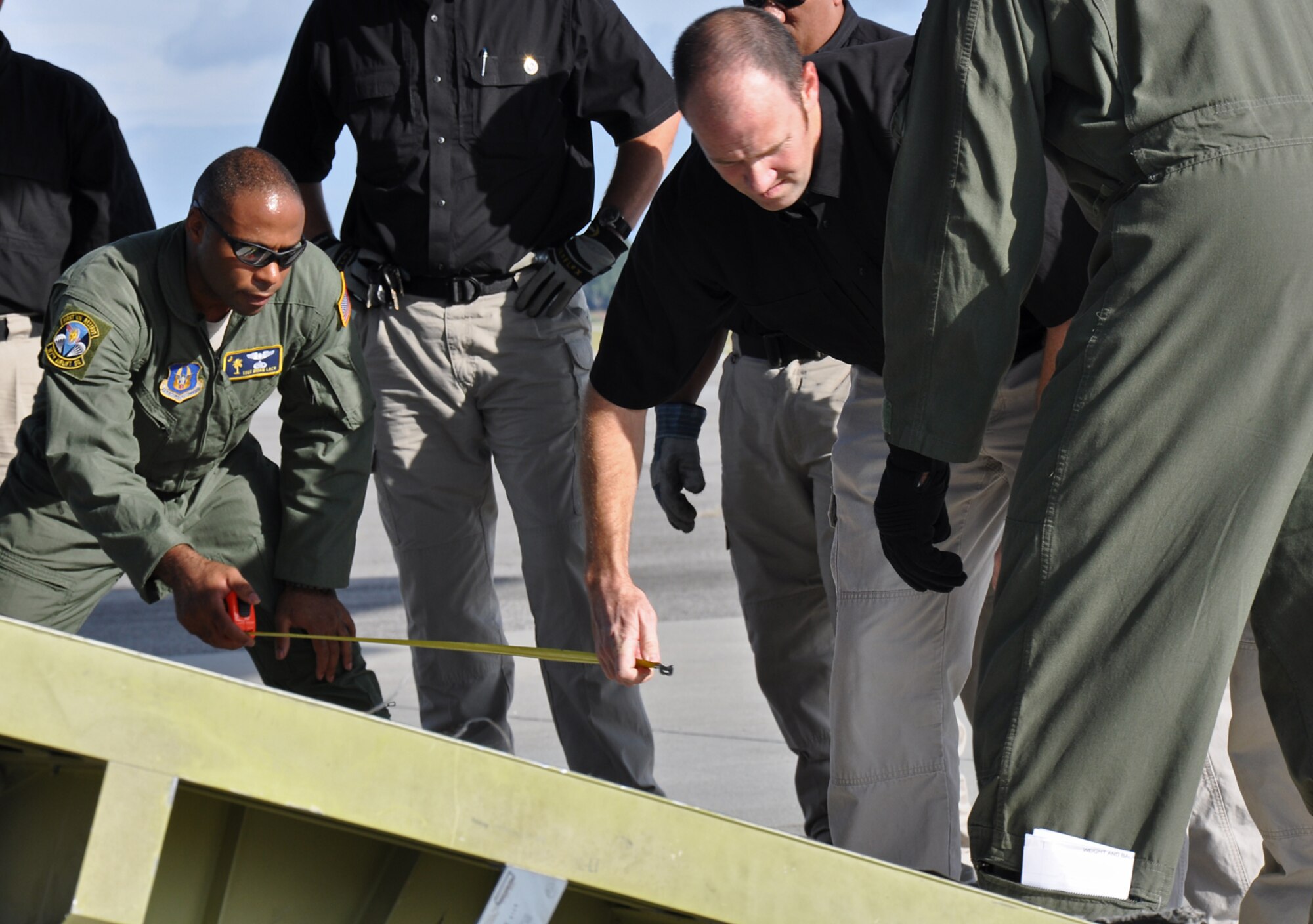 Tech. Sgt. Brian Lacy, a loadmaster with the 315th Airlift Control Flight, measures the width of the loading ramps with a member of Department of Homeland Security’s Pod Support Team 5 during airlift load certification training Oct. 28 at Joint Base Charleston, S.C.  (U.S. Air Force Photo/Airman 1st Class Robert Pilch)