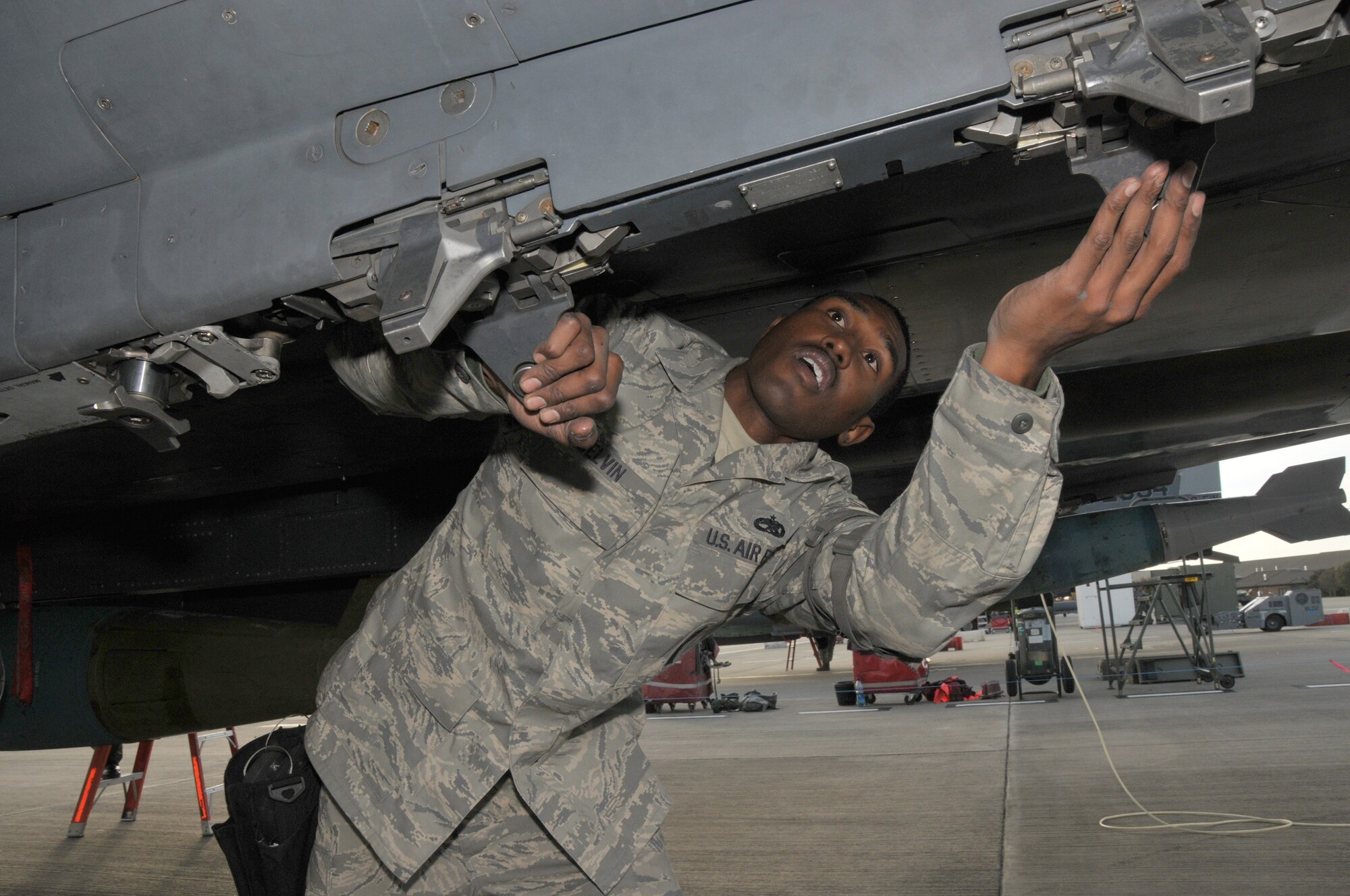ROYAL AIR FORCE LAKENHEATH, England – Staff Sgt. Arthur Belvin, 48th Aircraft Maintenance Squadron weapons team chief, performs a weapons post load inspection to ensure bombs are secured and loaded correctly on an F-15 during the operational readiness inspection Oct. 27.  The 48th Fighter Wing was tested on its worldwide responsive combat air power and its support in meeting the nation’s objectives.  (U.S. Air Force photo/Staff Sgt.  Connor Estes)