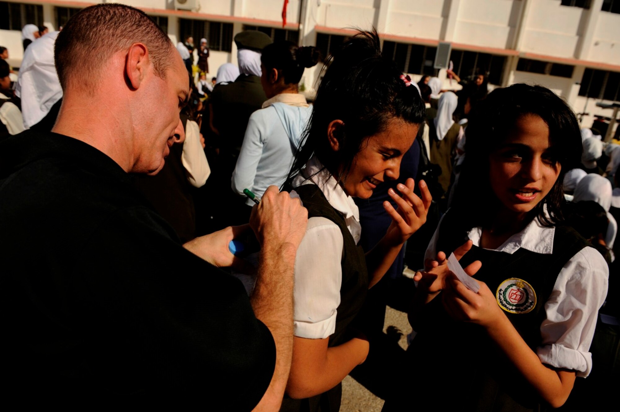 U.S. Air Force Staff Sgt. Marshall Gentry from U.S. Air Forces Central Band "Galaxy" signs autographs after a performance for students at Fatime Zahra' School for Girls in Amman, Jordan, Oct. 27, 2010.  Galaxy performs for audiences throughout Southwest Asia to help build relations with international partners.  (U.S. Air Force Photo/Staff Sgt. Eric Harris)