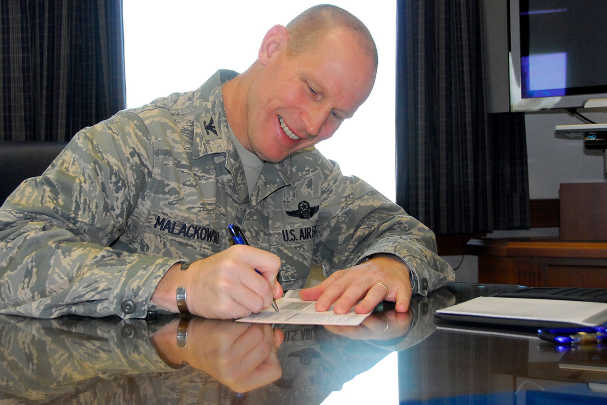 Col. Patrick C. Malackowski, 51st Fighter Wing commander, signs his Combined Federal Capaign donation form at Osan Air Base, Republic of Korea Oct. 28. Last year Team Osan raised more than $270,000 during the campaign. This year, there is a participation goal of 40 percent and a 100 percent informed opportunity to give goal. So far, Osan has raised $100,000 in CFC donations. To contribute, or for more information on the program, contact your unit CFC representative. (U.S. Air Force photo/Staff Sgt. Eunique Stevens) 