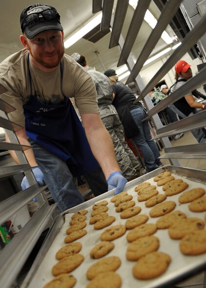 Jeff Cowan unloads a tray of cookies from a cart during the annual "Cookie Crunch" at Osan Air Base Oct. 28.  "Cookie Crunch" is sponsored by the Osan Officers' Spouses' Club. More than 80,000 cookies will be baked in the Mustang Club kitchen for all single and unaccompanied military members stationed at Air Force installations in the Republic Of Korea for delivery in mid-December. (U.S. Air Force/Senior Airman Evelyn Chavez)

