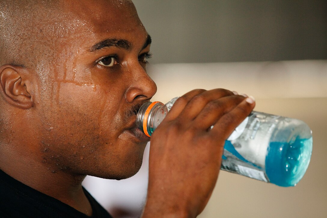 Staff Sgt. Jerrand Carr, assistant operations chief, C-20 Operations, Marine Corps Air Station Kaneohe Bay, Hawaii, refuels in the middle of a taxing Insanity Workout at Hangar 105 on MCAS, Oct. 29, 2010. Following the 60-day program, users perform the 30 to 40 minute workouts on a six-day-a-week schedule. The workouts can be done individually or with a group, and allow users to tailor their output based on their fitness level.