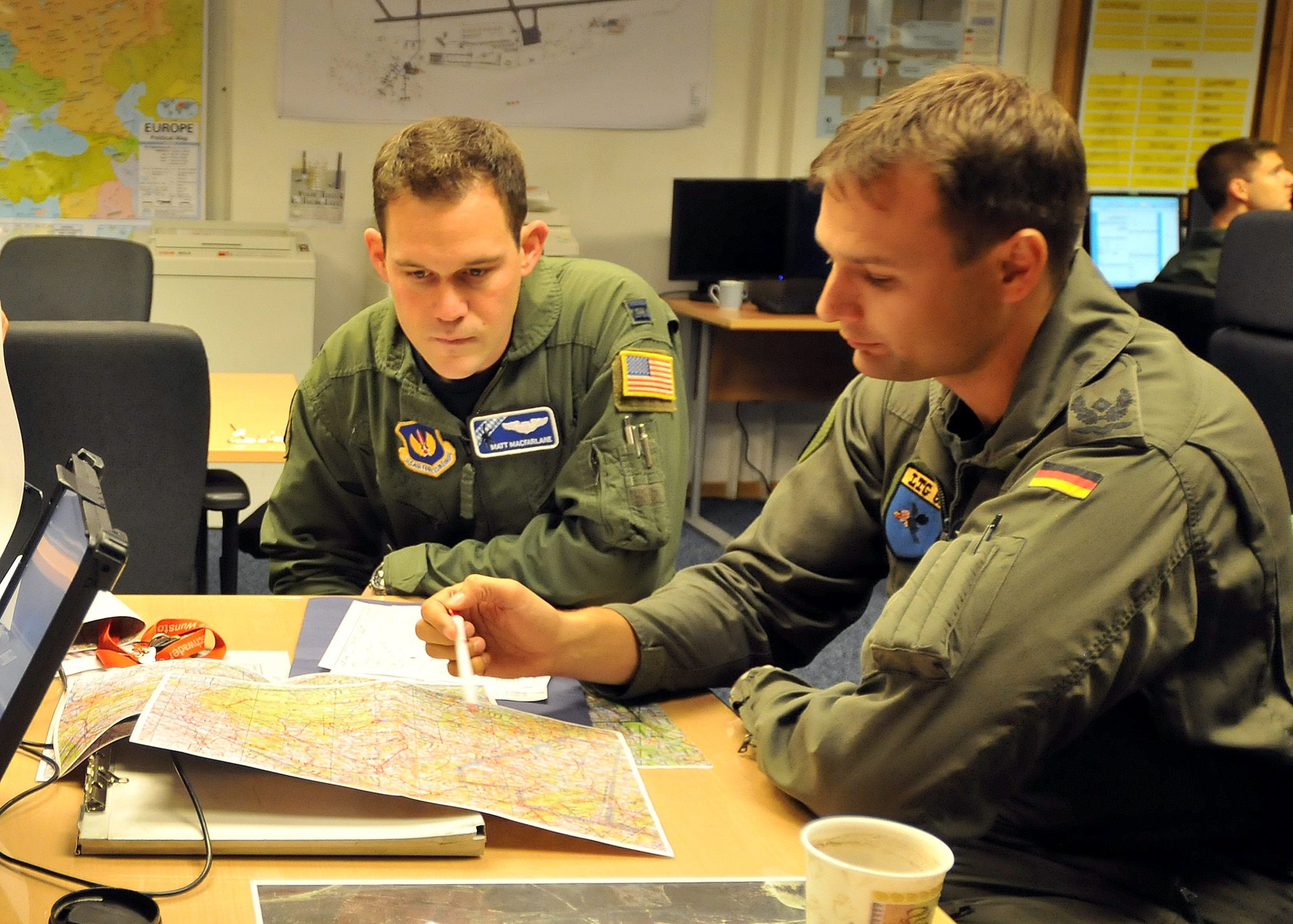 Capt. Matt Macfarlane, 37th AS tactics officer and German Major Stefan Schipke, Lufttransportgeschwader 62 squadron leader, plan a joint training mission. Eleven German aircrew members and two C-160 aircraft spent a week training with the 37th Oct. 25 through 29.
