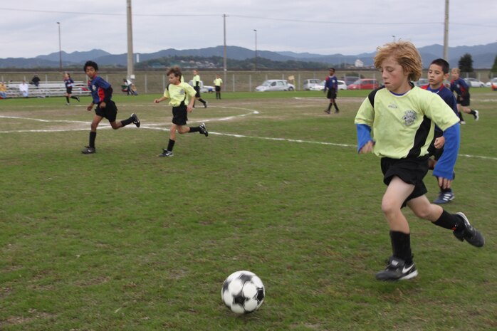 Andrew Park, a Yellow Jackets player, runs the ball down the field during the second half of a youth soccer playoff game at the Penny Lake soccer fields here Saturday. The Yellow Jackets were eliminated from the tournament after losing to the Mighty Strikers 2-0. The Yellow Jackets took third place overall in the youth soccer playoffs.